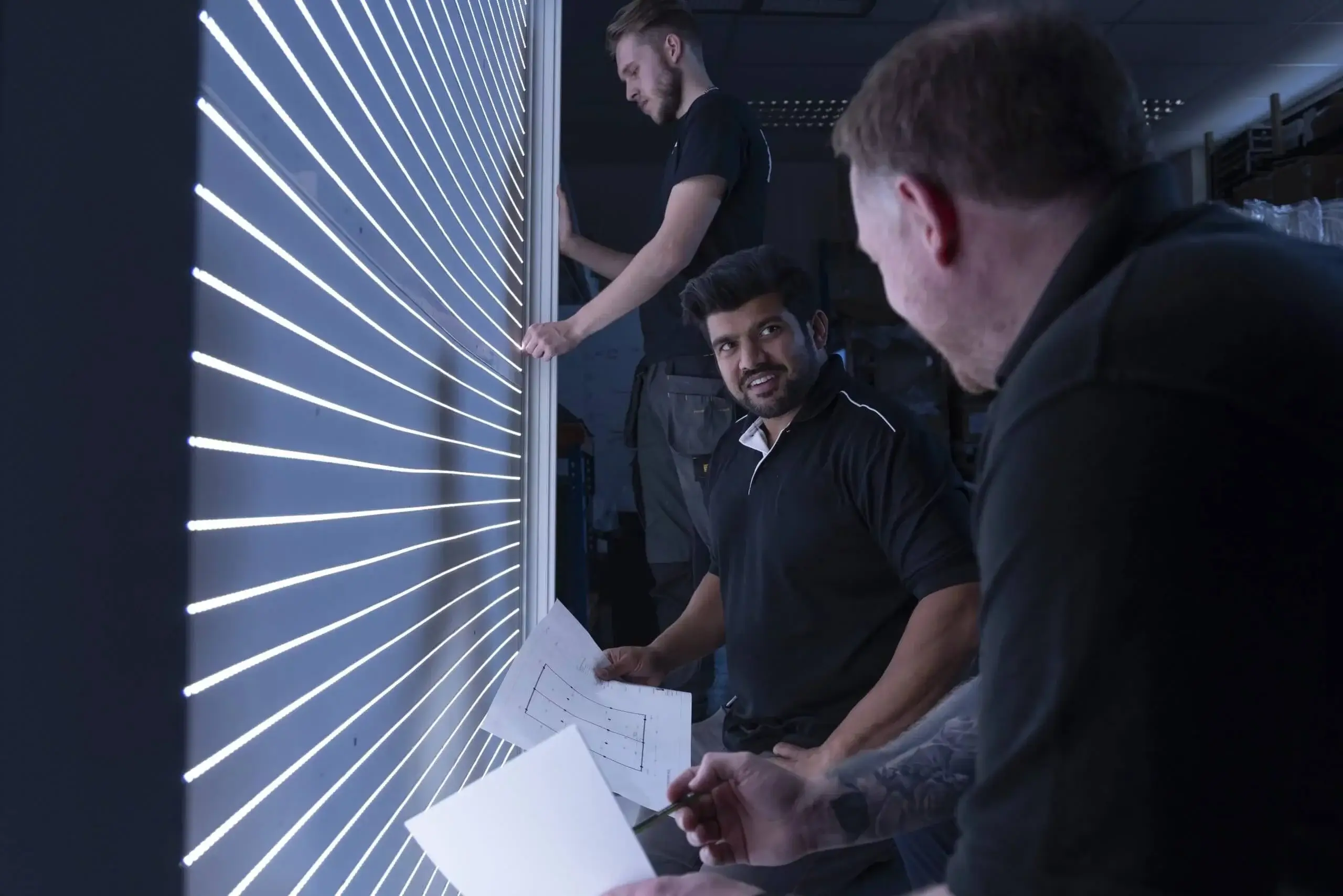 Engineers laying LED strip lighting